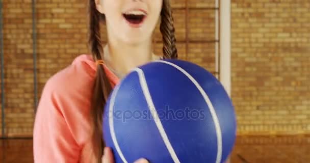 Chica de secundaria de pie con el baloncesto en la cancha — Vídeos de Stock