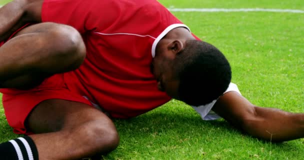 Jogador de futebol ferido deitado na grama — Vídeo de Stock