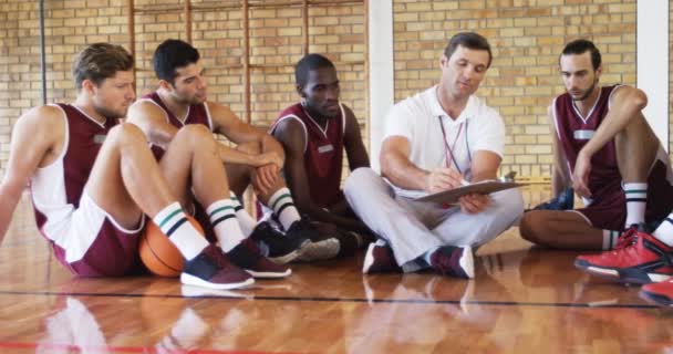 Trenér vysvětluje herní plán s basketbalisty — Stock video