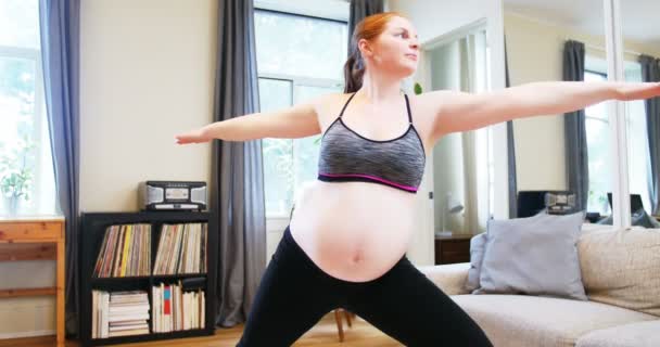 Mujer embarazada practicando yoga en salón — Vídeos de Stock