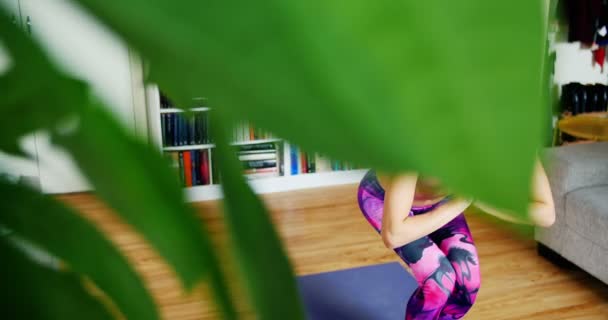 Mulher bonita praticando ioga na sala de estar — Vídeo de Stock