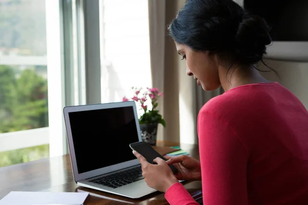 Mulher com laptop usando telefone — Fotografia de Stock