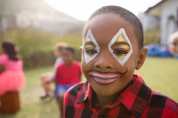 Pojke med ansiktsmålning stående i gården — Stockfoto