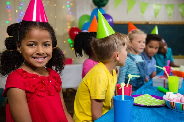 Lächelndes Mädchen sitzt mit Freunden — Stockfoto