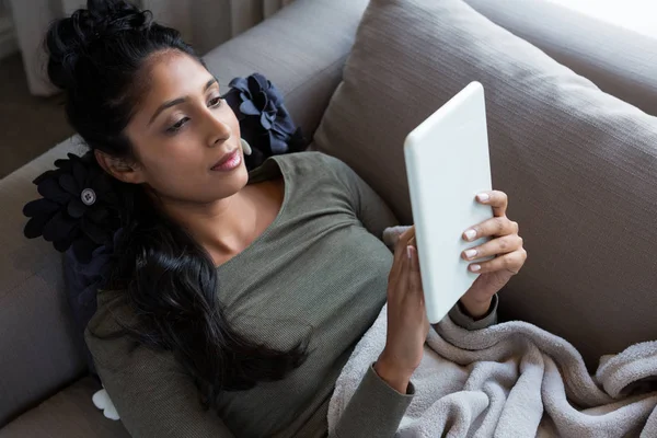 Vrouw met digitale tablet op de bank — Stockfoto