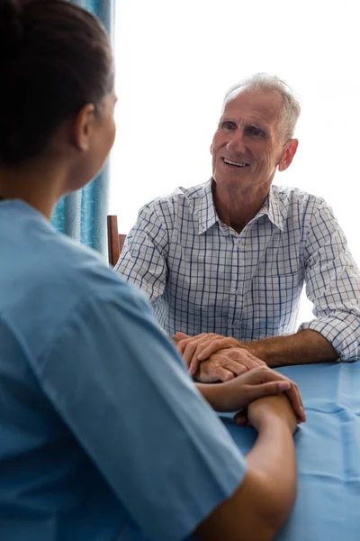 Homem conversando com médico feminino à mesa — Fotografia de Stock