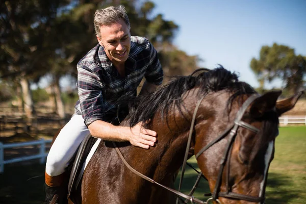 Άνδρα ενώ καβαλά άλογο στο αγρόκτημα — Φωτογραφία Αρχείου