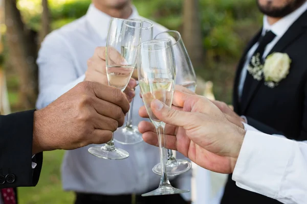 Brudgummen och gäster rostningen glas champagne — Stockfoto