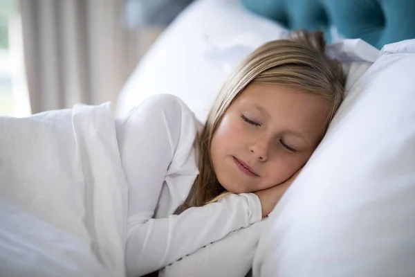 Chica durmiendo en la cama en el dormitorio — Foto de Stock