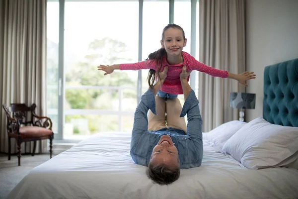 Otec, který zvedá její dcera na posteli — Stock fotografie