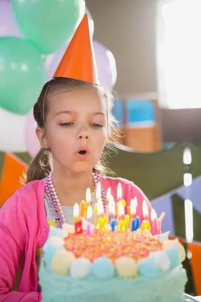 Девушка задувает свечи на день рождения — стоковое фото