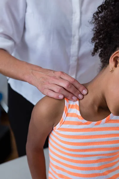 Physiotherapeutin gibt Mädchen Nackenmassage — Stockfoto