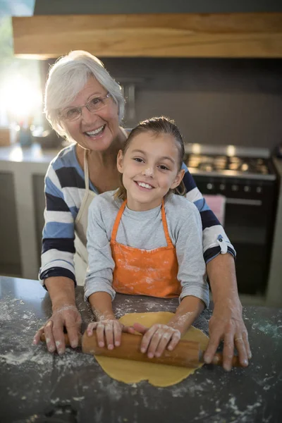 Büyükanne torunu hamuru düzleştirmek için yardım — Stok fotoğraf