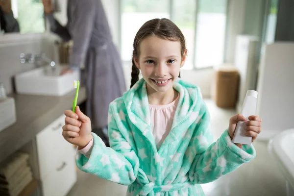Meisje houdt van tandpasta en tandenborstel in de badkamer — Stockfoto