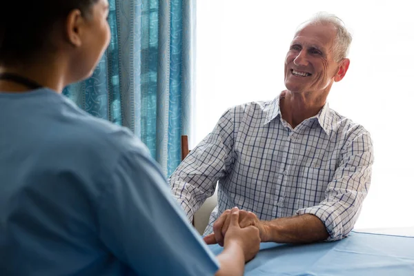 Arzt hält Hand an Seniorin — Stockfoto