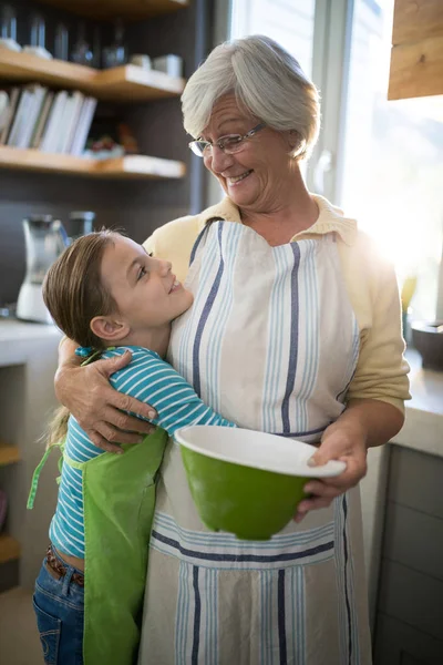 Γιαγιά και εγγονή Αγκαλιάζοντας στην κουζίνα — Φωτογραφία Αρχείου