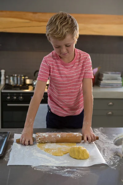 Хлопчик прокату тіста на кухні — стокове фото