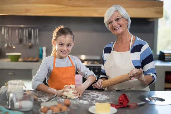 Granddaughter kneading dough — Stock Photo, Image