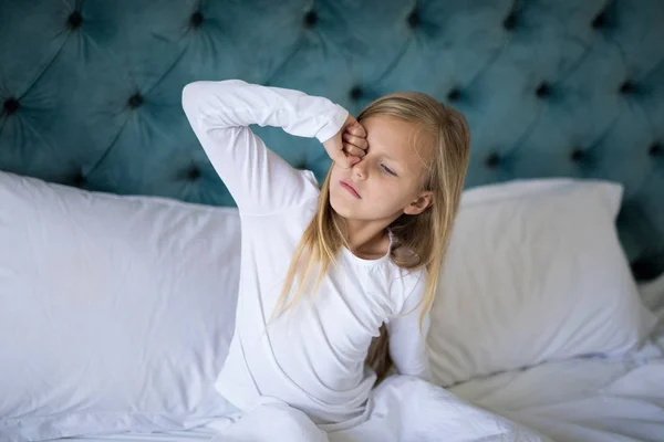 Menina acordando na cama no quarto — Fotografia de Stock