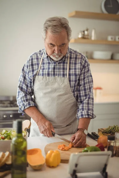 Senior man hakken groenten — Stockfoto