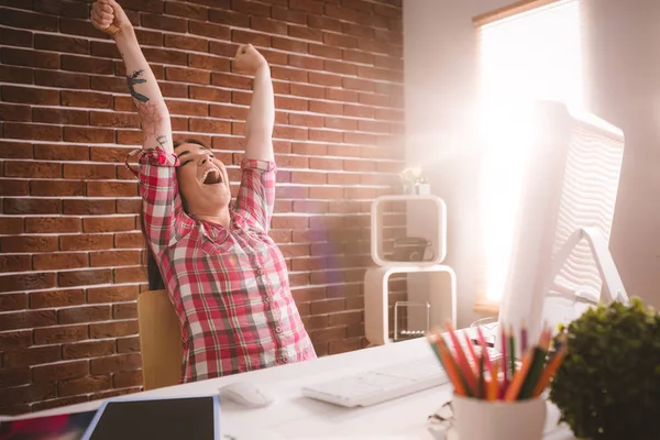 Vrouwelijke uitvoerend uitrekken handen op haar Bureau — Stockfoto