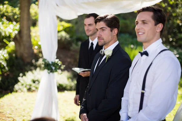 Groom standing with waiter and groomsman — Stock Photo, Image