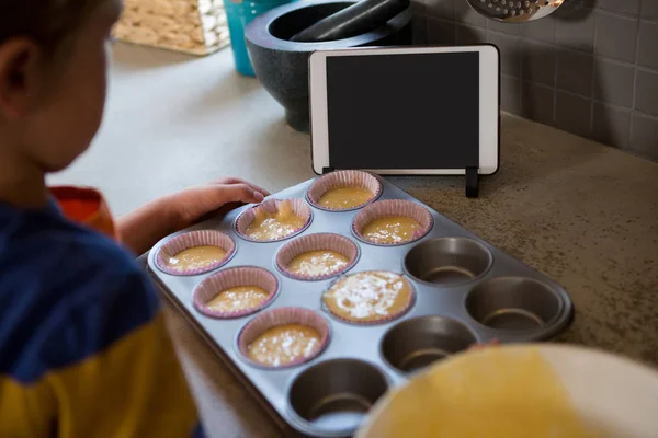 Menino segurando lata de muffin com cupcake — Fotografia de Stock
