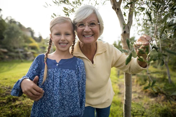 Barnbarn och mormor i trädgården — Stockfoto