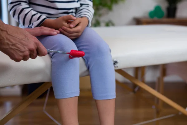 Läkaren undersöker reflexer av patientens knä — Stockfoto