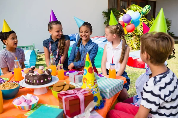 Children talking at table in yard — Stock Photo, Image