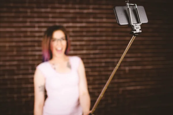 Frau macht Selfie vom Selfie-Stick — Stockfoto