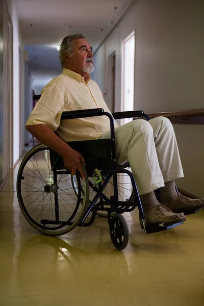 Tekerlekli sandalye üzerinde oturan düşünceli üst düzey adam — Stok fotoğraf