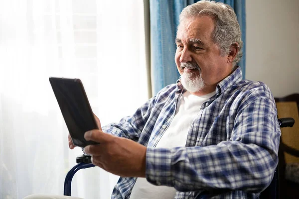 Homem idoso usando tablet em cadeira de rodas — Fotografia de Stock
