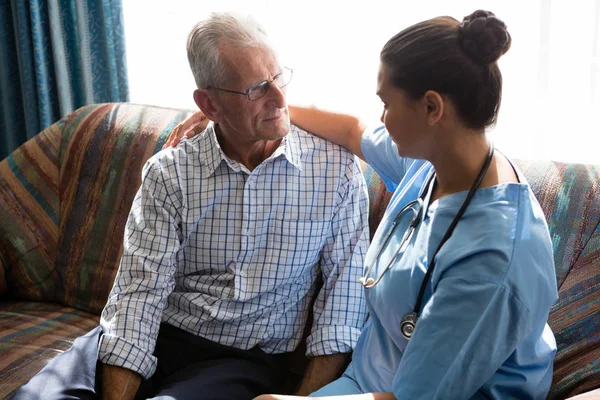 Läkare tröstande senior mannen — Stockfoto