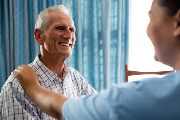 Старший чоловік розмовляє з лікарем-жінкою — стокове фото