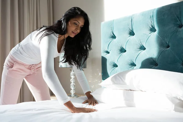 Mujer joven haciendo la cama —  Fotos de Stock