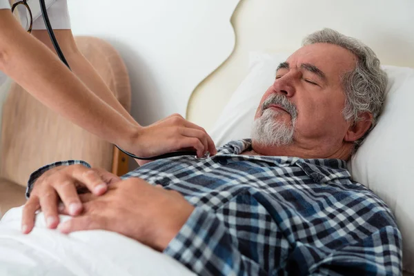 Händerna på läkare Lyssna på hjärtslag av man — Stockfoto