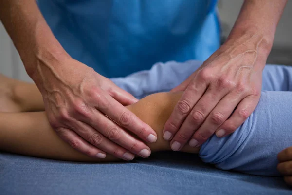 Fisioterapeuta dando massagem nas pernas ao paciente — Fotografia de Stock