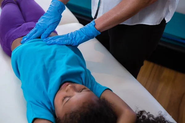 Физиотерапевт делает девушке массаж живота — стоковое фото