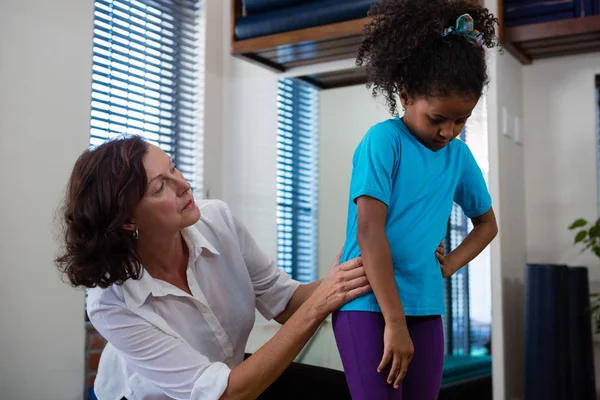 Physiotherapeutin gibt Mädchen Rückenmassage — Stockfoto