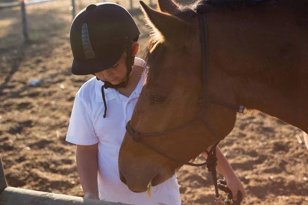 Rapaz a alimentar o cavalo no rancho — Fotografia de Stock