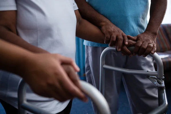 Friend assisting woman in walking with walker — Stock Photo, Image