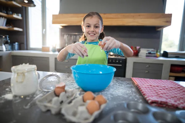 Smiling girl breaking egg — Stock Photo, Image