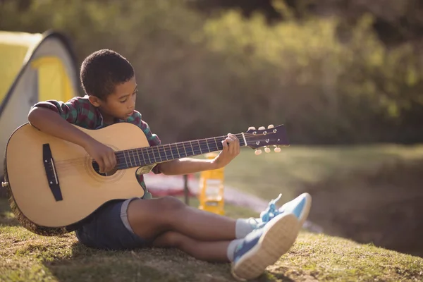 Usměvavý kluk hrál na kytaru v parku — Stock fotografie