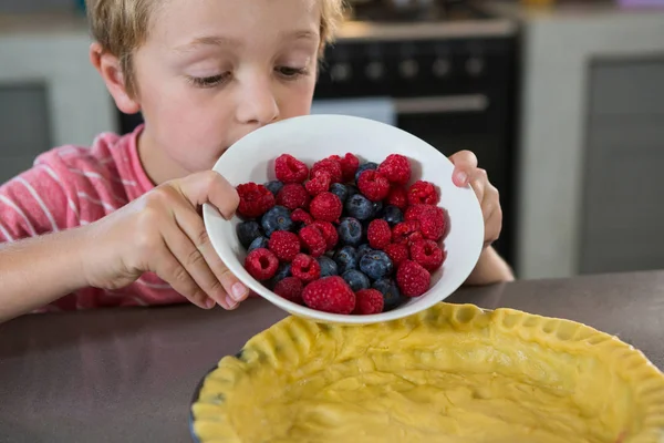 Menino preparando torta com bagas — Fotografia de Stock