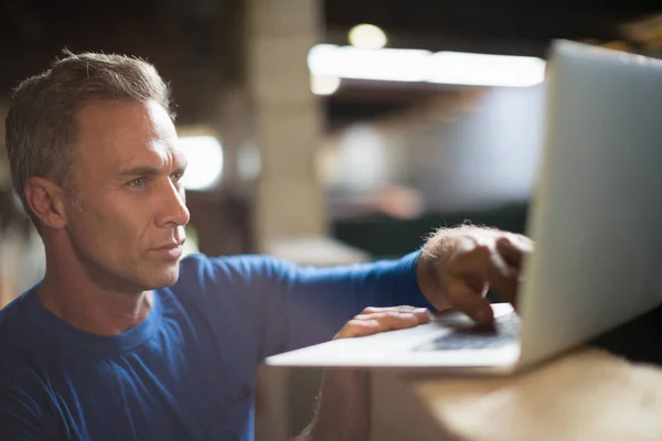 Man met laptop in de stal — Stockfoto