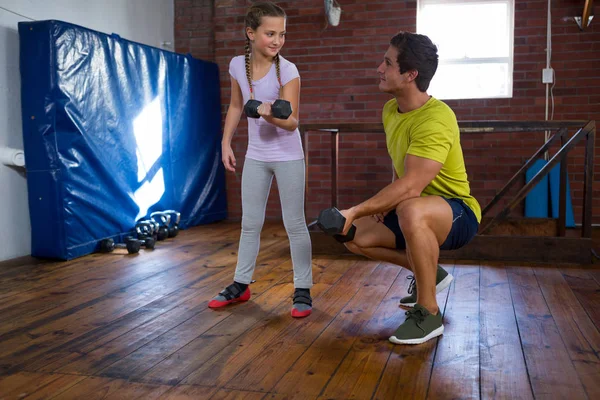 Treinador ajudando adolescente no exercício — Fotografia de Stock