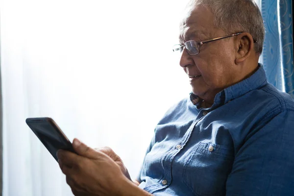 Старший чоловік використовує планшет в будинку престарілих — стокове фото