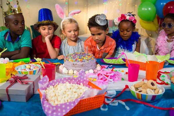 Děti při pohledu na narozeninový dort na stůl — Stock fotografie