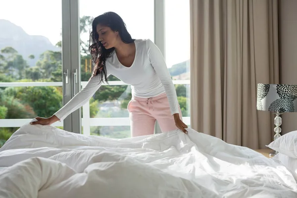 Woman making bed at home — Stock Photo, Image
